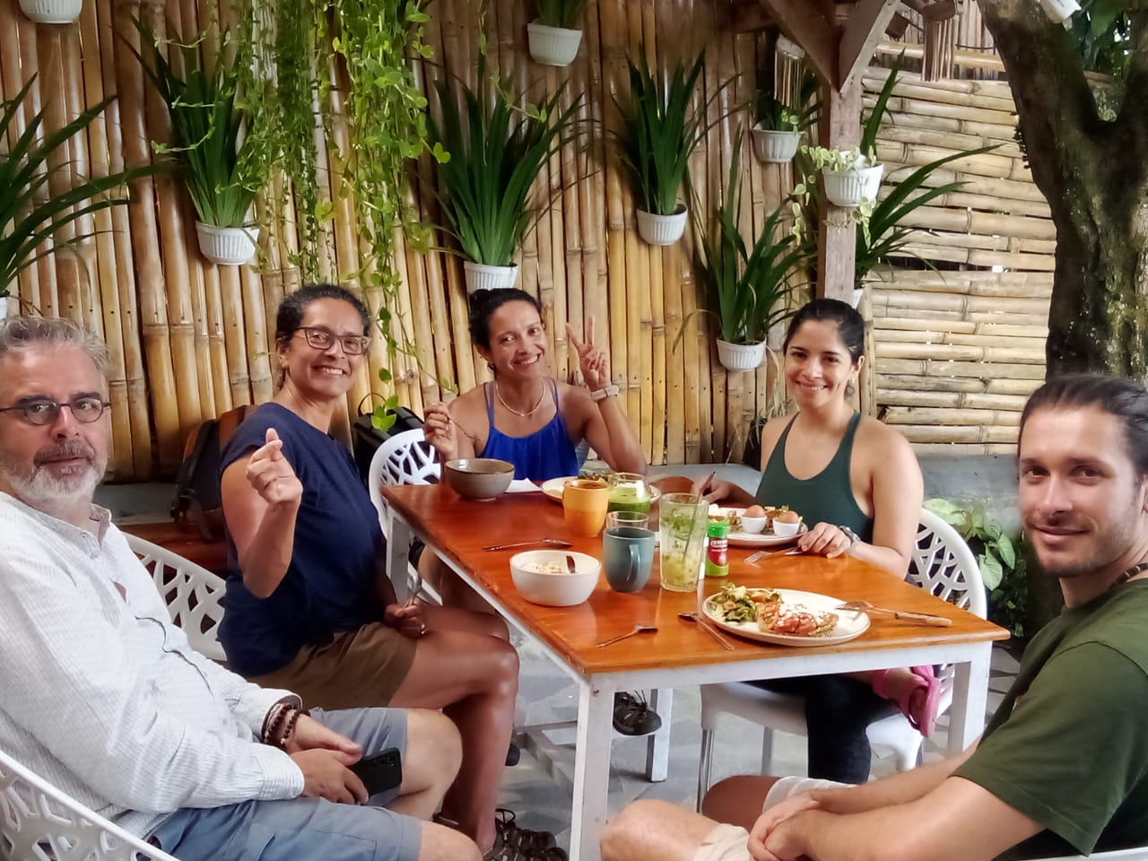 Guests sharing lunch at a table by the bamboo wall