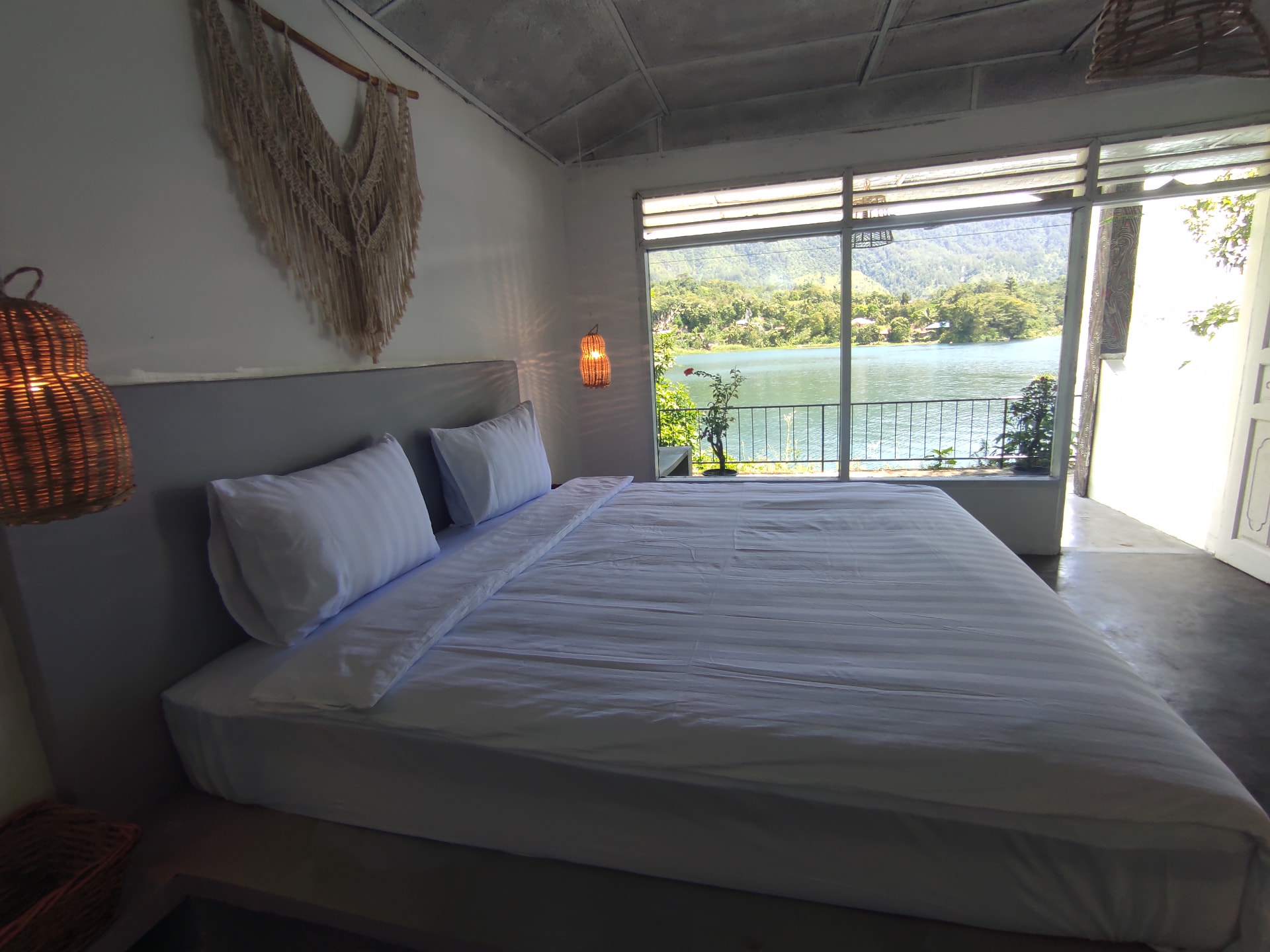 Double room with a big bed and window looking onto Lake Toba