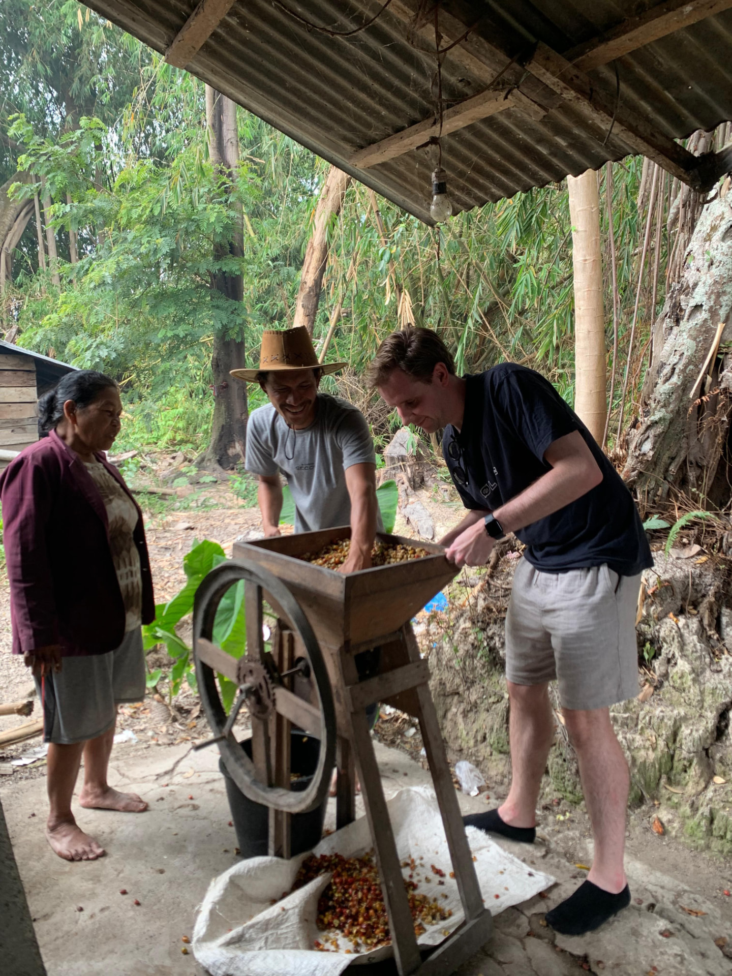 A guest grinding coffee beans with a local farmer