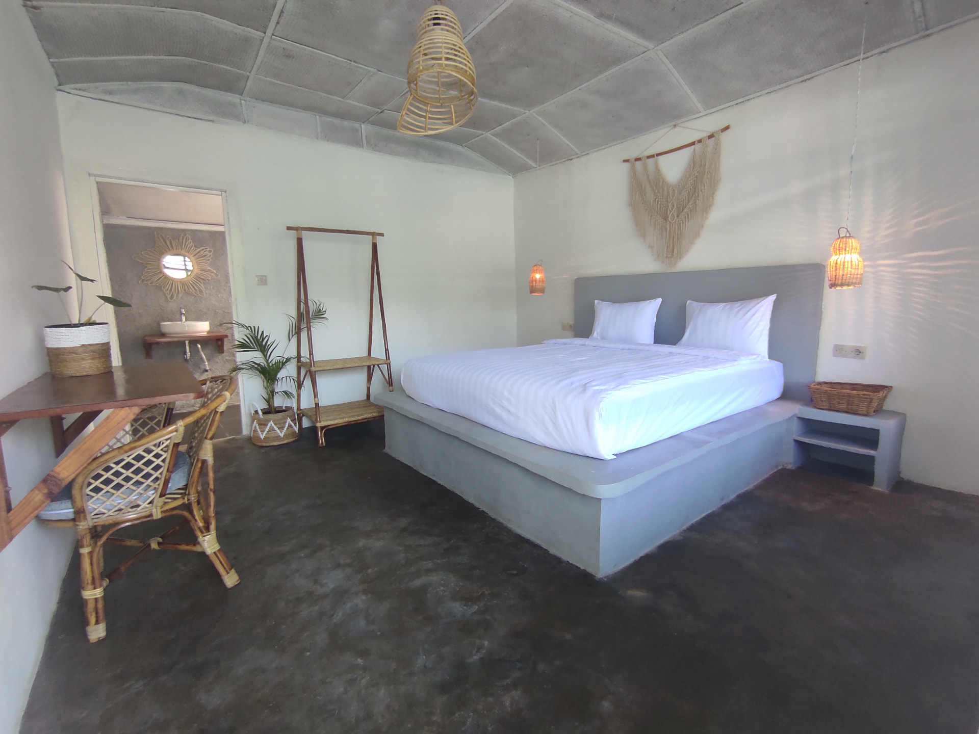 Double Room with Lakeview — bed, desk and rattan chair with woven pendant lamps